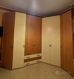 armadio ad angolo dotato di 7 ante e 4 cassetti