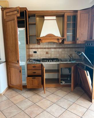 Cucina ad angolo in legno con elettrodomestici