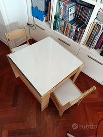 Tavolino con sedie. Con contenitori porta oggetti.