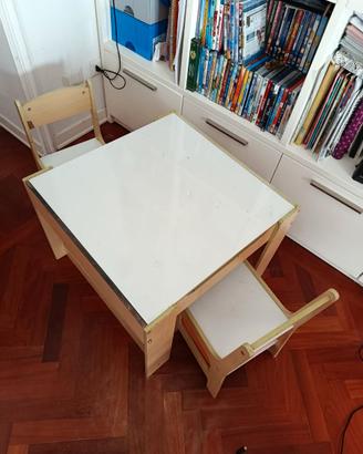 Tavolino con sedie. Con contenitori porta oggetti.