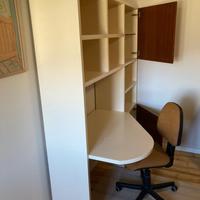 Angolo studio per camera con letto e arredi