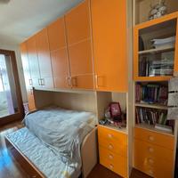 Camera a ponte arancione doppio letto e libreria
