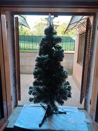 Albero di Natale con luci e stella colorata in cim