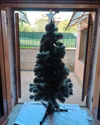 Albero di Natale con luci e stella colorata in cim