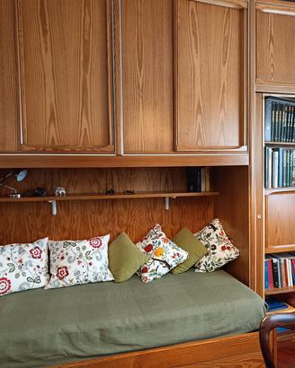 Intera camera con armadi/letti/librerie in legno.