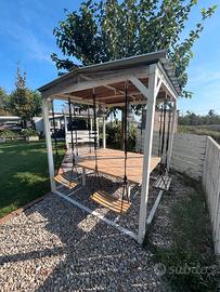 Gazebo da giardino con tavolo e sedie altalene.