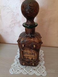 Vecchia bottiglia in vetro rivestita in cuoio.