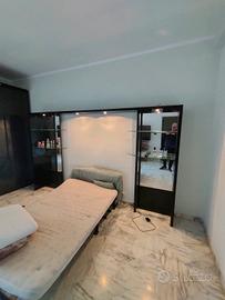 contorno letto con faretti e mensole in cristallo 