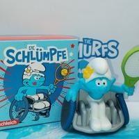 Puffi Vanitoso in sedia a rotelle che gioca a tenn