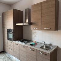 Cucina completa di elettrodomestici e tavolo con 4