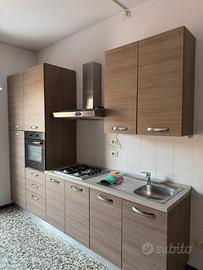 Cucina completa di elettrodomestici e tavolo con 4