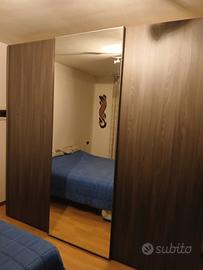 armadio ante scorrevoli grigio con specchio centra