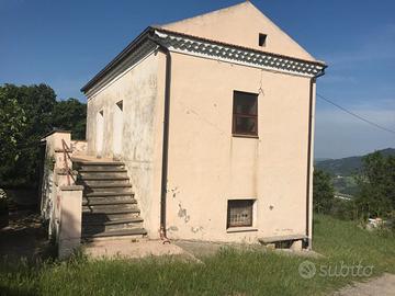 Casolare in pietra con terreno circostante