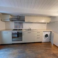 Cucina lineare con arredamento vario