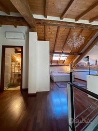 Loft di charme su due livelli con travi a vista