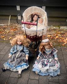 Tre bambole grandi, un bambolotto, una carrozzina