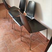 Quattro sedie nere in legno e acciaio