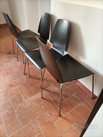 Quattro sedie nere in legno e acciaio