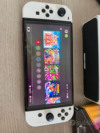 Nintendo switch oled con accessori e gioco.