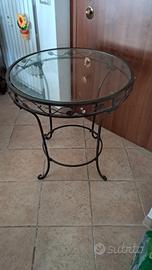 Tavolo in ferro battuto con piano in vetro.