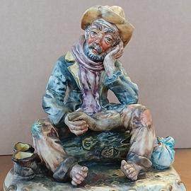 Statuina in ceramica di Capodimonte: uomo seduto