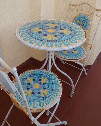 Tavolino rotondo  con sedie in ferro battuto.