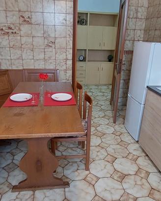 Cassapanca angolare e tavolo da cucina in legno.