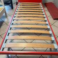 Letto singolo con doghe rosso, armadio e mensolo