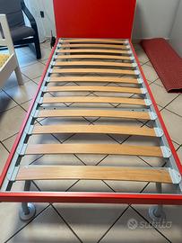 Letto singolo con doghe rosso, armadio e mensolo