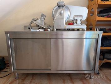 Tavolo inox con ante e ripiano.