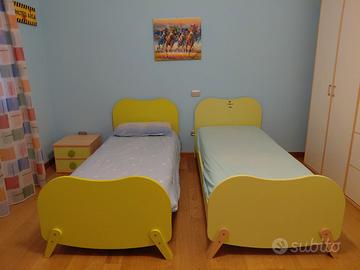 2 letti verdi singoli con comodino 