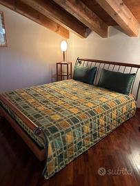 Letto matrimoniale con comodino e lampada