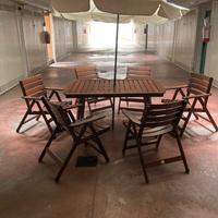 Tavolo da giardino con ombrellone e sedie