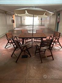 Tavolo da giardino con ombrellone e sedie