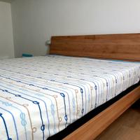 Letto matrimoniale con doghe in legno e materasso