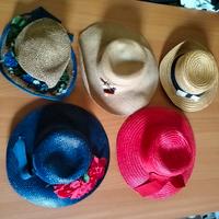 cappelli di paia di vari colori decorati 