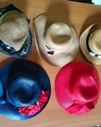cappelli di paia di vari colori decorati 