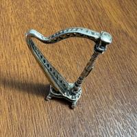 Arpa in argento con corde in lenza.