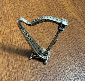 Arpa in argento con corde in lenza.