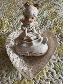 Fanciulla su base a forma di cuore, in ceramica.