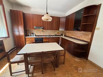 Cucina completa in legno con tavolo e legno