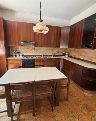 Cucina completa in legno con tavolo e legno