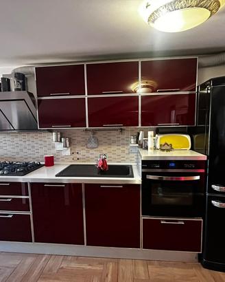 Cucina moderna rossa lucida con elettrodomestici