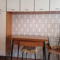 Cucina con pensili, tavolo e sedie