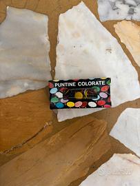 Una scatolina di puntine da disegno colorate