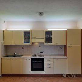 Cucina con tavolo/sedie e divano, camera da letto