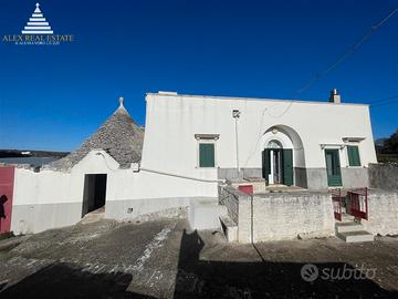 Ancient manor house with stone trulli and lamie