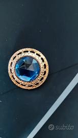 Spilla vintage dorata con pietra blu