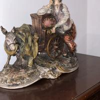 Scultura  di uomo con carion e asinello