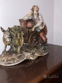 Scultura  di uomo con carion e asinello